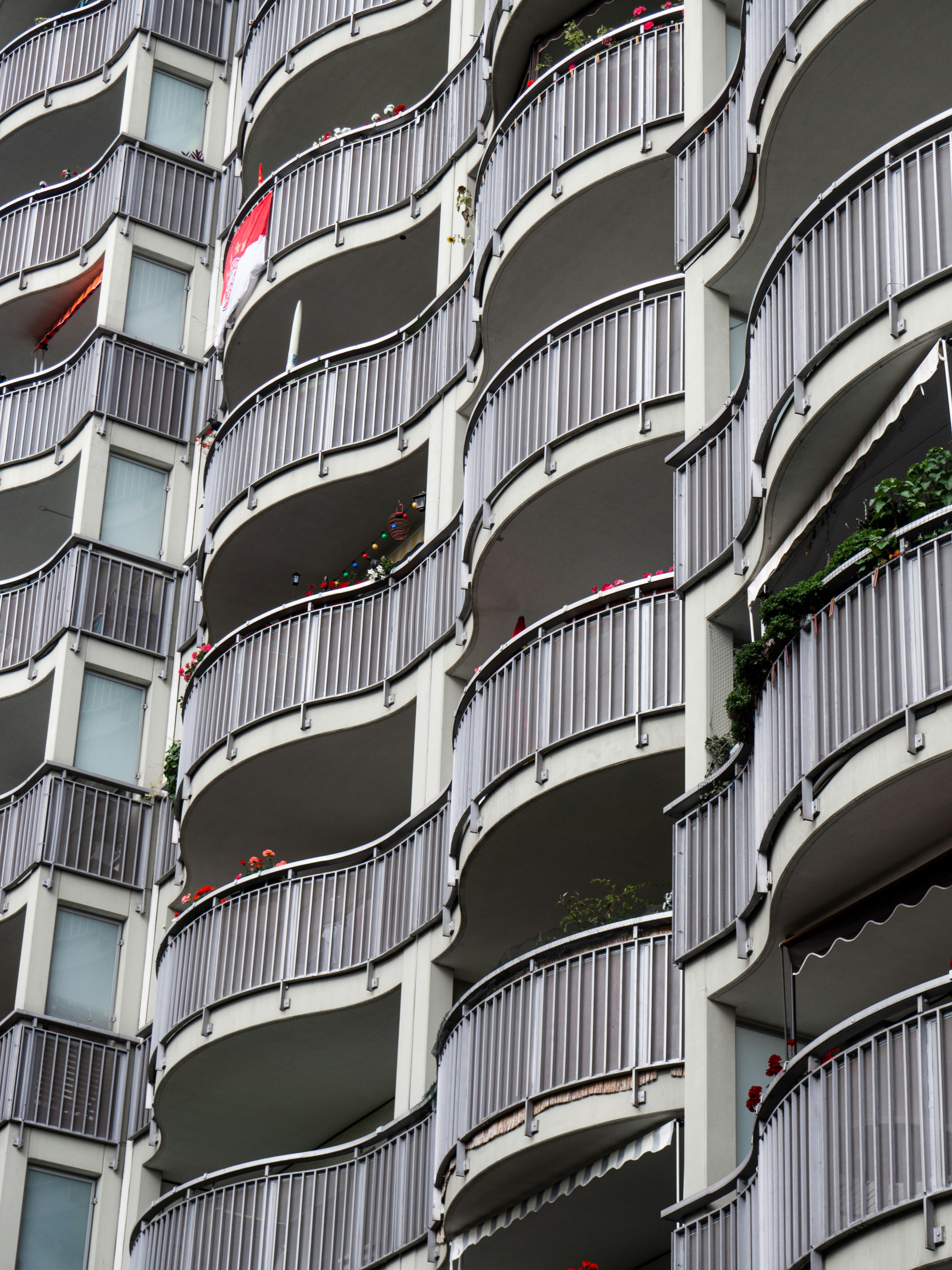 white concrete building with red and white windows